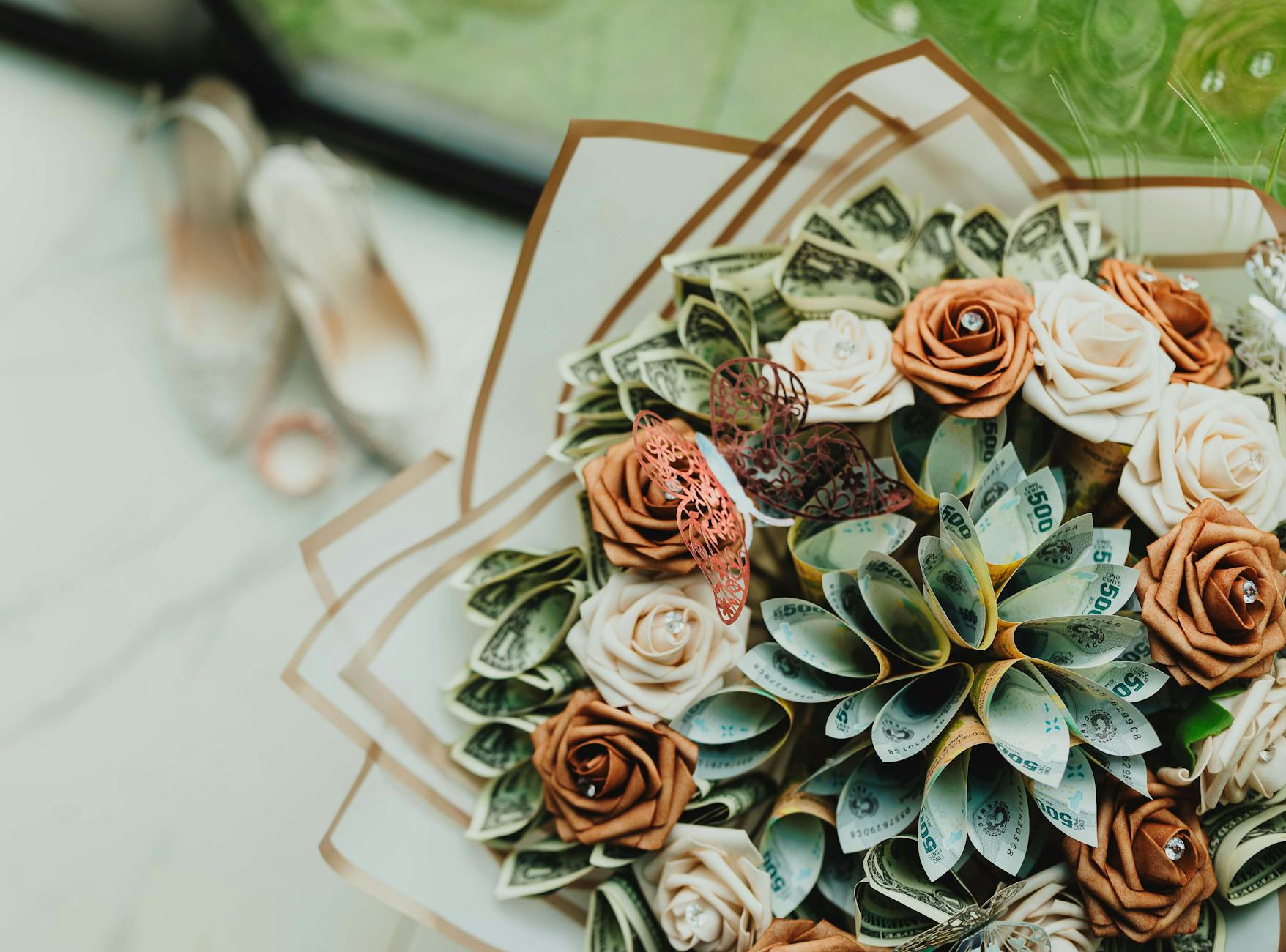 Bukiet papierowych kwiatów z banknotami i motylem jako dekoracja ślubna