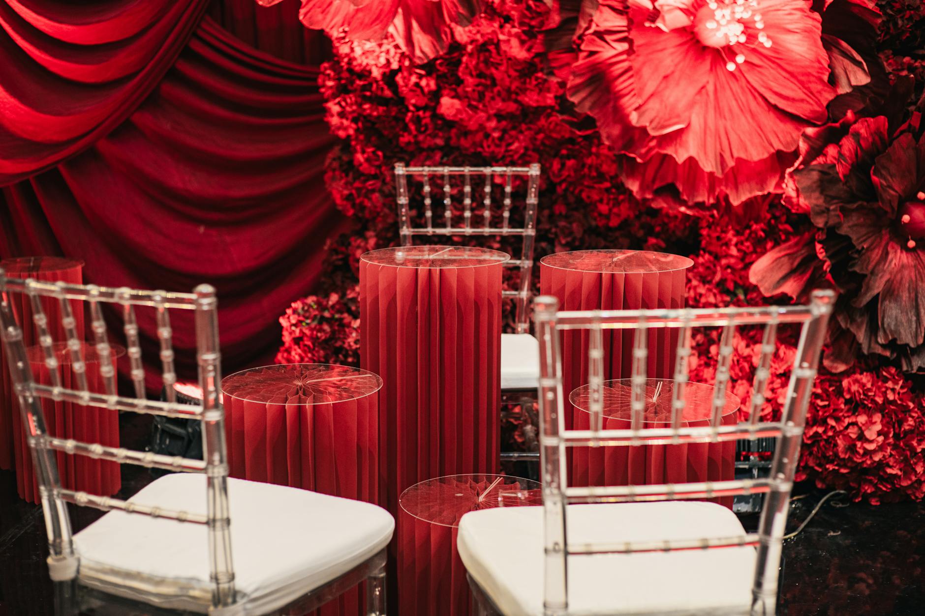 Luksusowa bordowa dekoracja ślubna z kwiatami i przezroczystymi krzesłami